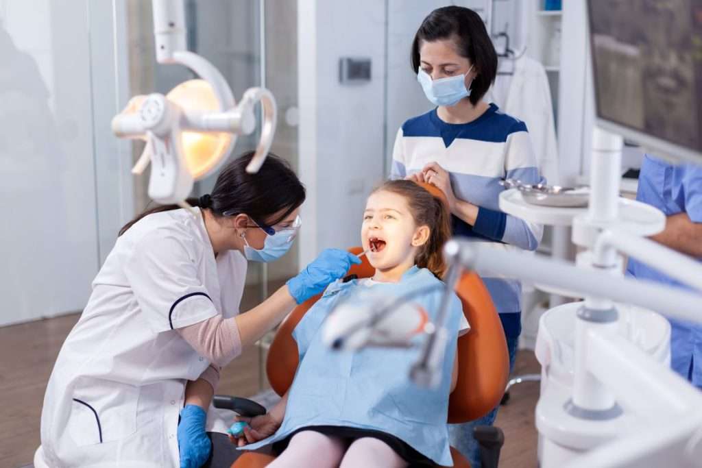 Dentist performing kids dental cleaning. Child with parent in attendance. Mississauga Smiles Dentistry, Mississauga.